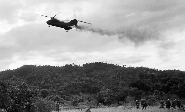 FILE- A U.S. Marine CH-46 Sea Knight helicopter comes down in flames after being hit by enemy ground fire during Operation Hastings, just south of the Demilitarized Zone between North and South Vietnam, July 15, 1966. The helicopter crashed and exploded on a hill, killing one crewman and 12 Marines. Three crewman escaped with serious burns. (AP Photo/Horst Faas. File)