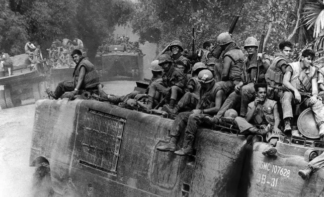 FILE- An amphibious tracked vehicle with a load of fully-armed Marines approaches a river southwest of Danang, South Vietnam, Aug. 22, 1969. (AP Photo/Horst Faas, File)