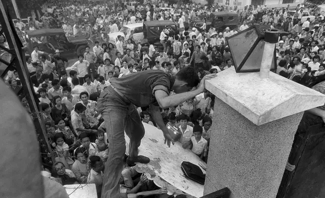 FILE - In this April 29, 1975, file photo, South Vietnamese civilians try to scale the 14-foot wall of the U.S. embassy in Saigon, trying to reach evacuation helicopters as the last Americans departed from Vietnam. (AP Photo/File)
