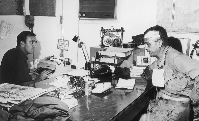 Wounded Associated Press photographer Al Chang gives an account of the battle in which he was injured at Bien Hoa, to AP correspondent Peter Arnett in Saigon, Dec. 1965. Chang was wounded Dec. 18 in a fight with Viet Cong in which five paratroopers died. (AP PhotoAP Corporate Archives)