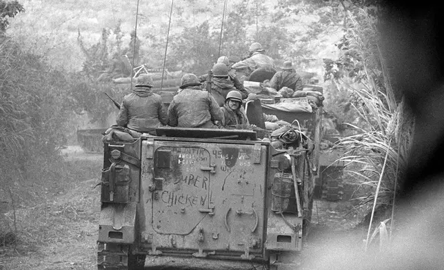 Soldiers of the Americal Divison ride on armored personnel carriers toward Lang Vel Special Forces camp, half a mile from the Laotian border during the Vietnam War, 1971. The Americans had to clear Route 9 to the Laotian border for Operation Lam Son 719, the South Vietnamese invasion into Laos. Photo from one of the last rolls of film before photographer Henri Huet was killed with three other photojournalists covering the operation. (AP Photo/Henri Huet)