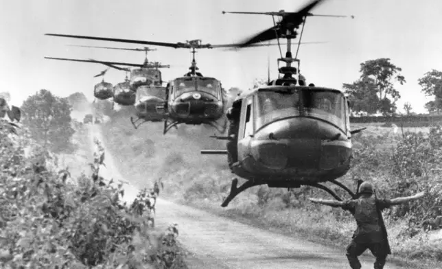 FILE- Huey helicopters, carrying troops of the U.S. 173rd Airborne Brigade, settle in for a landing near the Montagnard village of Plei Ho Drong in August 1965. The unit found friendly mountain tribal people, but no Viet Cong. (AP Photo/Horst Faas, File)