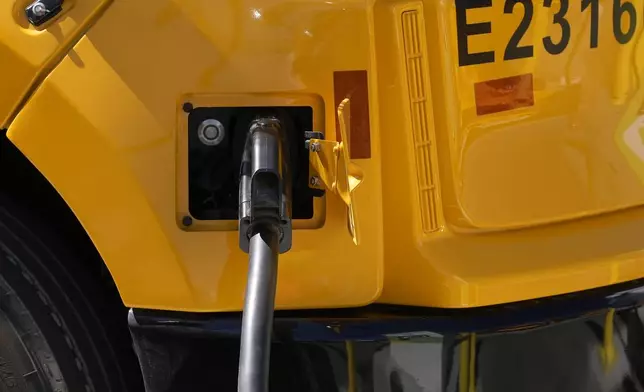 FILE - A Zum electric bus is plugged into charging a station before a news conference announcing the Oakland Unified School District as being the first major school district in the country to use 100% electric school buses at the Zum/OUSD bus yard in Oakland, Calif., on Aug. 27, 2024. (AP Photo/Jeff Chiu, File)