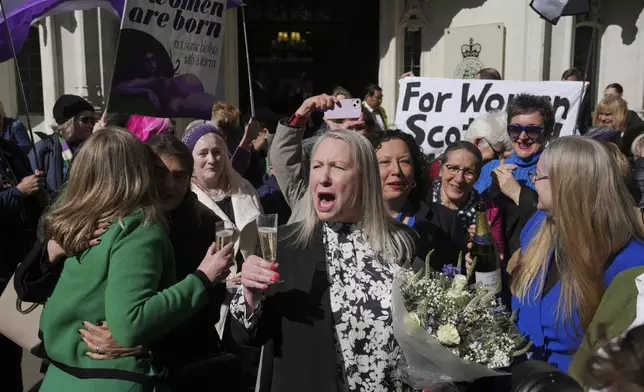 Marion Calder, center, and Susan Smith, left, from For Women Scotland, celebrate outside after the U.K. Supreme Court ruled that a woman is someone born biologically female, excluding transgender people from the legal definition in a long-running dispute between the feminist group and the Scottish government, in London Wednesday, April 16, 2025. (AP Photo/Kin Cheung)