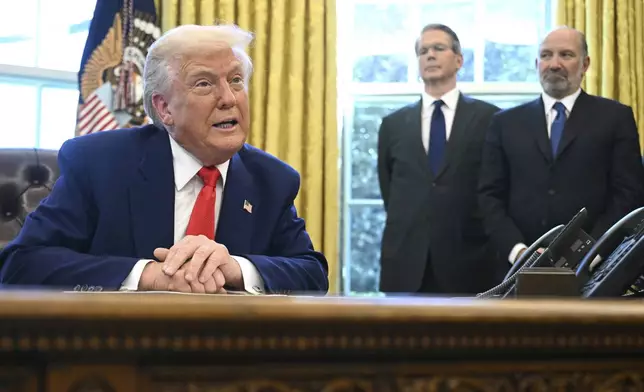 President Donald Trump speaks after signing an executive order in the Oval Office of the White House Wednesday, April 9, 2025, in Washington, as Treasury Secretary Scott Bessent and Commerce Secretary Howard Lutnick listen. (Pool via AP)