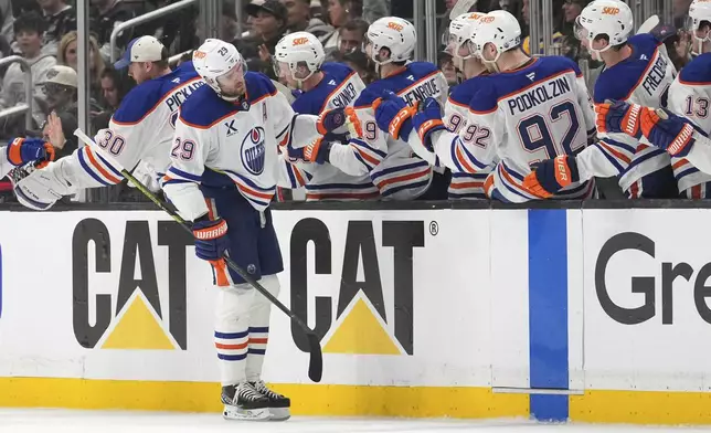Edmonton Oilers center Leon Draisaitl is congratulated by teammates after scoring during the second period in Game 1 of an NHL hockey first-round playoff series against the Los Angeles Kings Monday, April 21, 2025, in Los Angeles. (AP Photo/Mark J. Terrill)