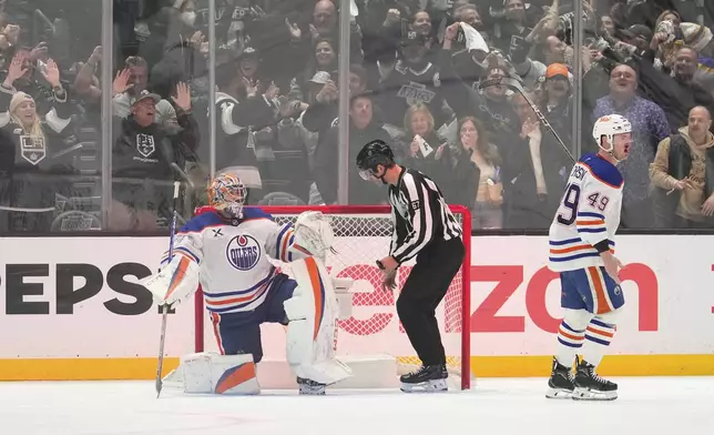 Edmonton Oilers defenseman Ty Emberson, right, skates away with a bloody nose after Los Angeles Kings center Anze Kopitar scored as goaltender Stuart Skinner sits in goal during the third period in Game 2 of an NHL hockey first-round playoff series Wednesday, April 23, 2025, in Los Angeles. (AP Photo/Mark J. Terrill)