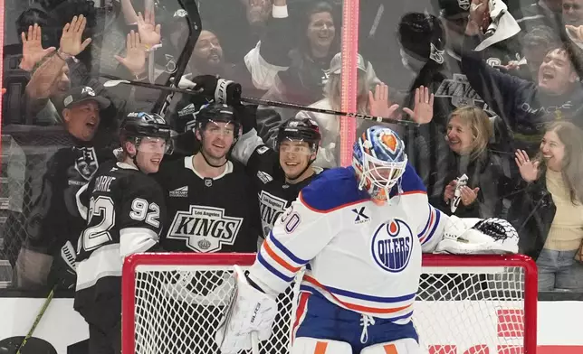 Los Angeles Kings right wing Adrian Kempe, second from left, celebrates his goal with defenseman Brandt Clarke, left, and left wing Andrei Kuzmenko, second from right, as Edmonton Oilers goaltender Calvin Pickard stands in goal during the third period in Game 2 of an NHL hockey first-round playoff series Wednesday, April 23, 2025, in Los Angeles. (AP Photo/Mark J. Terrill)
