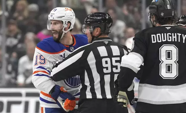 Edmonton Oilers center Adam Henrique yells at a member of the Los Angeles Kings as a linesman holds him back while defenseman Drew Doughty watches during the third period in Game 2 of an NHL hockey first-round playoff series Wednesday, April 23, 2025, in Los Angeles. (AP Photo/Mark J. Terrill)