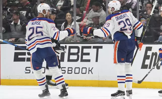 Edmonton Oilers center Leon Draisaitl, right, is congratulated by defenseman Darnell Nurse after scoring during the second period in Game 1 of an NHL hockey first-round playoff series against the Los Angeles Kings, Monday, April 21, 2025, in Los Angeles. (AP Photo/Mark J. Terrill)