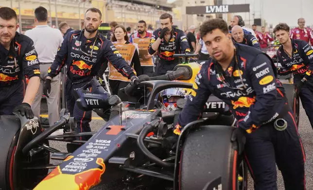 Mechanics push Red Bull driver Max Verstappen of the Netherlands on the starting grid before the the Formula One Bahrain Grand Prix, in Sakhir, Sunday, April 13, 2025. (AP Photo/Darko Bandic)