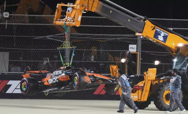 McLaren driver Lando Norris' car is carried out of the track after crashing during the qualifying session ahead of the Formula One Saudi Arabian Grand Prix at the Jeddah Corniche Circuit in Jeddah, Saudi Arabia, Saturday, April 19, 2025. (AP Photo/Altaf Qadri)
