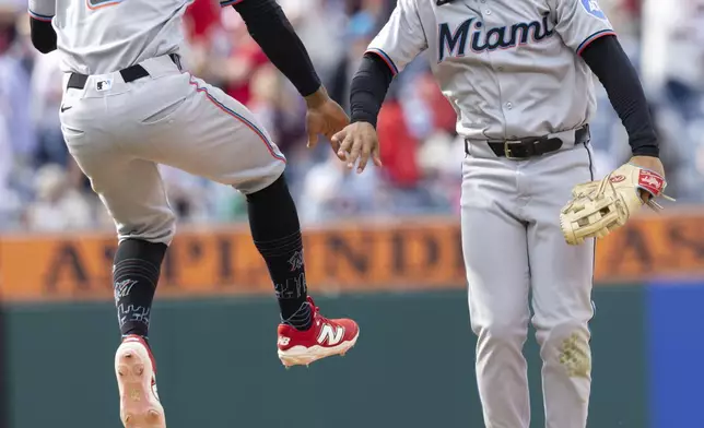 Miami Marlins second baseman Otto Lopez (6) and left fielder Javier Sanoja celebrate their win against the Philadelphia Phillies in a baseball game, Sunday, April 20, 2025, in Philadelphia. (AP Photo/Laurence Kesterson)