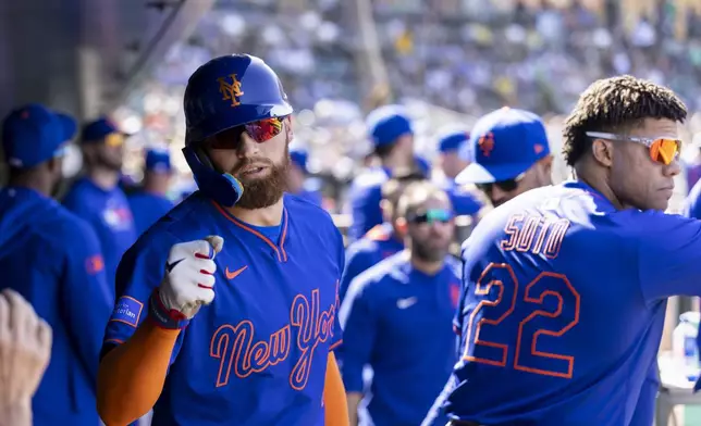 New York Mets' Brandon Nimmo (9) celebrates in the dugout after scoring during the seventh inning of a baseball game against the Athletics, Sunday, April 13, 2025, in West Sacramento, Calif. (AP Photo/Sara Nevis)