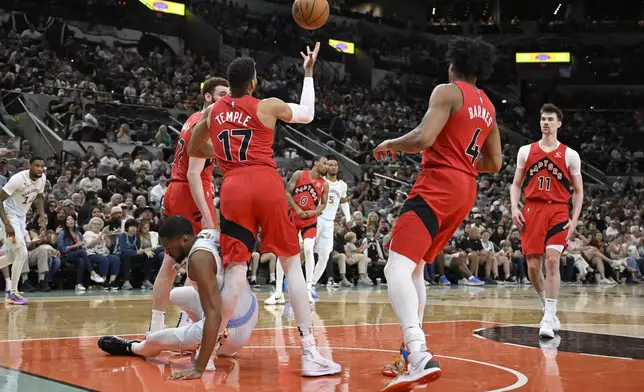 Toronto Raptors forward Garrett Temple (17) is injured as San Antonio Spurs guard Malaki Branham falls in the first half of an NBA basketball game, Sunday, April 13, 2025, in San Antonio. (AP Photo/Darren Abate)