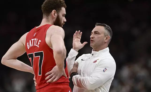 Toronto Raptors head coach Darko Rajakovic, right, speaks with Raptors forward Jamison Battle during the first half of their NBA basketball game against the San Antonio Spurs, Sunday, April 13, 2025, in San Antonio. (AP Photo/Darren Abate)