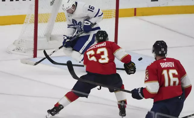 Toronto Maple Leafs right wing Mitch Marner (16) defends a shot on the goal by Florida Panthers center Brad Marchand (63) during the third period of an NHL hockey game, Tuesday, April 8, 2025, in Sunrise, Fla. (AP Photo/Lynne Sladky)