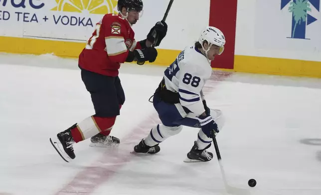 Toronto Maple Leafs right wing William Nylander (88) skates with the puck as Florida Panthers center Brad Marchand, left, defends during the third period of an NHL hockey game, Tuesday, April 8, 2025, in Sunrise, Fla. (AP Photo/Lynne Sladky)