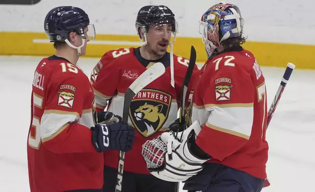 Florida Panthers center Brad Marchand (63) and goaltender Sergei Bobrovsky (72) talk at the end of an NHL hockey game against the Detroit Red Wings, Thursday, April 10, 2025, in Sunrise, Fla. (AP Photo/Marta Lavandier)