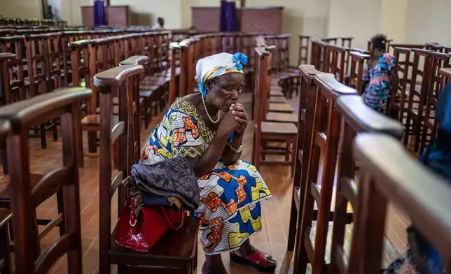 A woman prays during the morning mass at the Sanctuaire d'adoration cathedral, following the announcement of Pope Francis's death in Goma, Democratic Republic of Congo, Monday, April 21, 2025. (AP Photo/Moses Sawasawa)