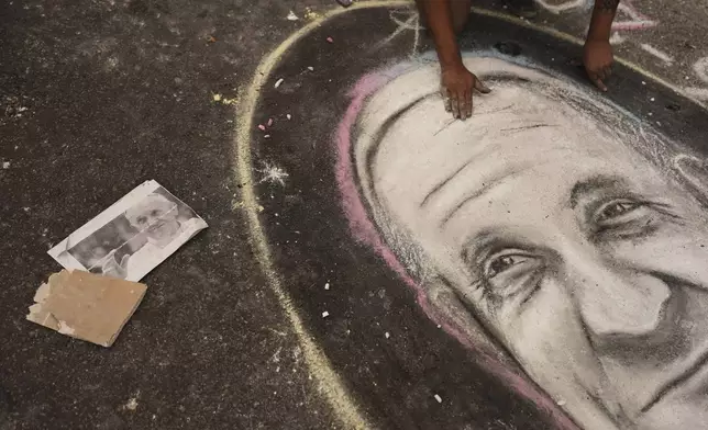 A street artists chalks a portrait of the late Pope Francis outside the Cathedral in Buenos Aires, Argentina, Tuesday, April 22, 2025. (AP Photo/Rodrigo Abd)