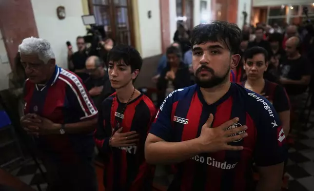 Fans of San Lorenzo soccer club attend a Mass at San Antonio Parish in honor of the late Pope Francis, a lifelong supporter of the club, in Buenos Aires, Argentina, Wednesday, April 23, 2025. (AP Photo/Natacha Pisarenko)