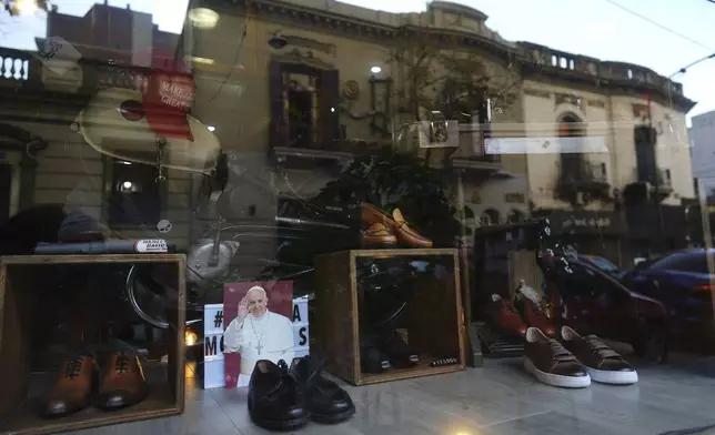 A photograph of the late Pope Francis sits in the window of the Muglia shoe store alongside the model of shoes that Jorge Bergoglio used in the Flores neighborhood where he grew up in Buenos Aires, Argentina, Thursday, April 24, 2025. (AP Photo/Natacha Pisarenko)