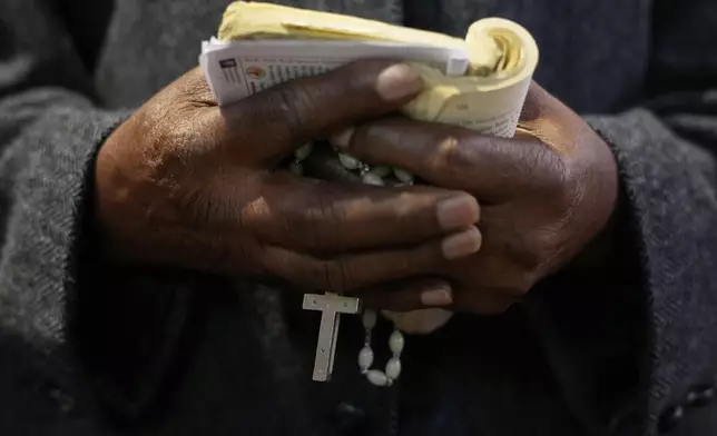 A Catholic holds a crucifix during Pope Francis Memorial Mass, at the Cathedral of Christ the King, Johannesburg, South Africa, Wednesday, April 23, 2025. (AP Photo/Themba Hadebe)
