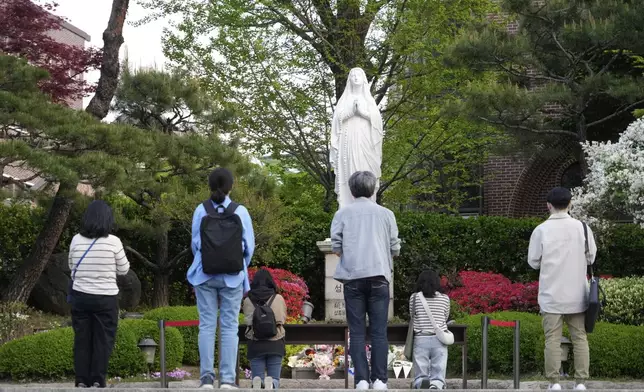 Catholic believers pray after the news of Pope Francis's death at Myeongdong Cathedral in Seoul, South Korea, Monday, April 21, 2025. (AP Photo/Ahn Young-joon)