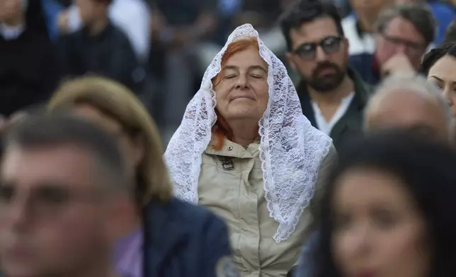 Faithful attend a rosary prayer for the late Pope Francis, in St. Peter's Square at the Vatican, Tuesday April 22, 2025. (AP Photo/Bernat Armangue)