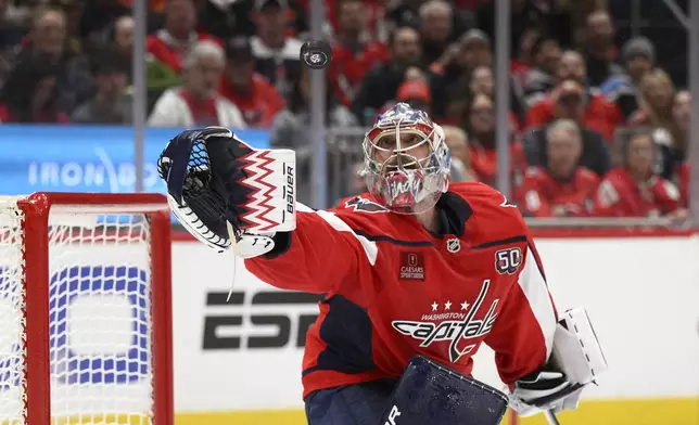 Washington Capitals goaltender Charlie Lindgren reaches for the puck during the second period of an NHL hockey game against the Carolina Hurricanes, Thursday, April 10, 2025, in Washington. (AP Photo/Nick Wass)