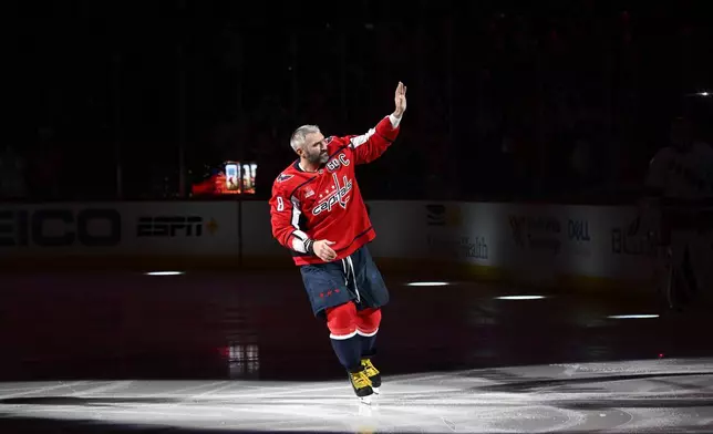 Washington Capitals left wing Alex Ovechkin (8) waves to the crowd as he takes part in a pre-game ceremony to honor him for scoring 895 career NHL goals before an NHL hockey game against the Carolina Hurricanes, Thursday, April 10, 2025, in Washington. (AP Photo/Nick Wass)