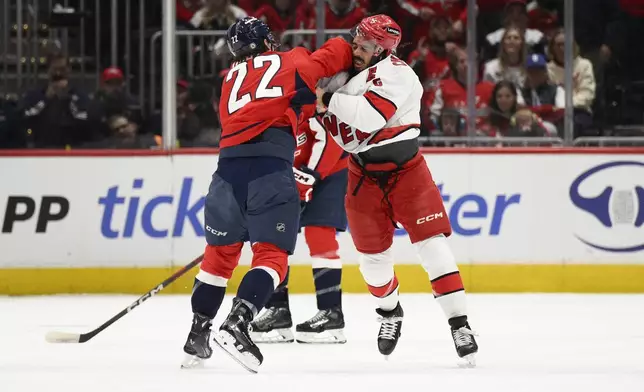 Washington Capitals right wing Brandon Duhaime (22) and Carolina Hurricanes defenseman Jalen Chatfield, right, fight during the first period of an NHL hockey game, Thursday, April 10, 2025, in Washington. (AP Photo/Nick Wass)