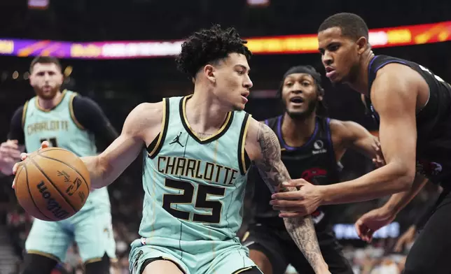 Charlotte Hornets' KJ Simpson (25) protects the ball from Toronto Raptors' Orlando Robinson (21) during first half NBA basketball action in Toronto on Wednesday, April 9, 2025. (/Frank Gunn/The Canadian Press via AP)