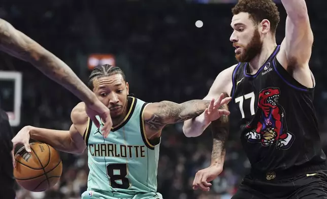 Charlotte Hornets' Nick Smith Jr. (8) protects the ball from Toronto Raptors' Jamison Battle (77) during first half NBA basketball action in Toronto on Wednesday, April 9, 2025. (Frank Gunn/The Canadian Press via AP)