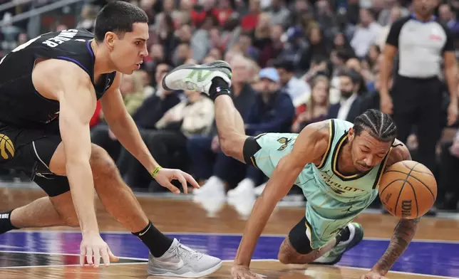 Charlotte Hornets' Nick Smith Jr., right, falls as Toronto Raptors' Cole Swider (12) defends during first half NBA basketball action in Toronto on Wednesday, April 9, 2025. (Frank Gunn/The Canadian Press via AP)