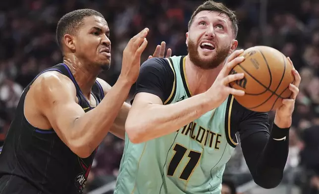 Charlotte Hornets' Jusuf Nurkic (11) protects the ball as Toronto Raptors' Orlando Robinson (21) defends during first half NBA basketball action in Toronto on Wednesday, April 9, 2025. (Frank Gunn/The Canadian Press via AP)
