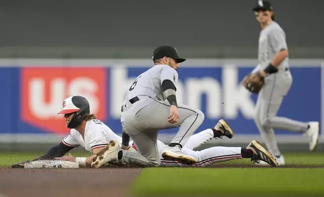 Minnesota Twins' Luke Keaschall (15) beats the tag by Chicago White Sox shortstop Jacob Amaya (8) to steal second base during the third inning of a baseball game Wednesday, April 23, 2025, in Minneapolis. (AP Photo/Abbie Parr)