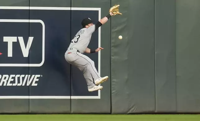 Chicago White Sox left fielder Andrew Benintendi (23) tries to catch a double hit by Minnesota Twins' Ryan Jeffers (27) during the second inning of a baseball game Wednesday, April 23, 2025, in Minneapolis. (AP Photo/Abbie Parr)