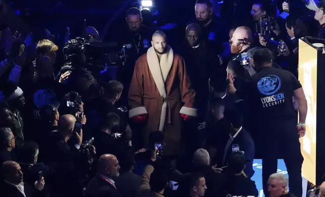 Chris Eubank Jr, accompanied by his father, Chris Eubank Sr., walks out ahead of his middleweight bout against Conor Benn at Tottenham Hotspur Stadium, London, Saturday, April 26, 2025. (Bradley Collyer/PA via AP)