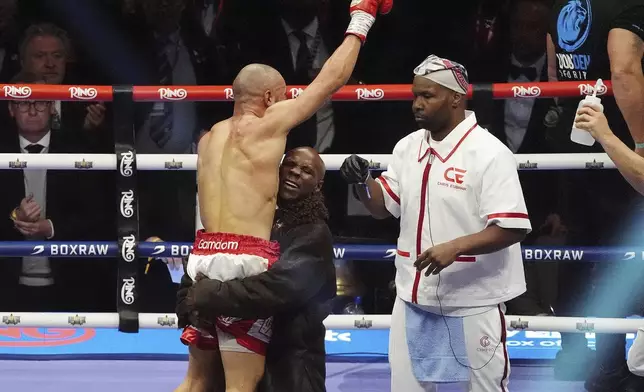 Chris Eubank Jr. is lifted by Chris Eubank Sr after winning a middleweight bout against Conor Benn at Tottenham Hotspur Stadium, London, Saturday, April 26, 2025. (Bradley Collyer/PA via AP)