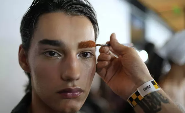 A model holds still for makeup backstage before the start of the Lino Villaventura collection at Sao Paulo Fashion Week, Tuesday, April 8, 2025. (AP Photo/Andre Penner)