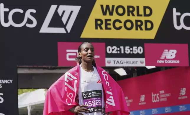 Tigst Assefa of Ethiopia poses for the cameras after setting a new women's only world record time and winning the women's race at the London Marathon, Sunday, April 27, 2025. (AP Photo/Alberto Pezzali)