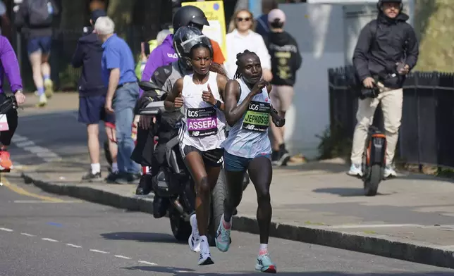 Kenya's Joyciline Jepkosgei, right, and Ethiopia's Tigst Assefa reach the Isle of Dogs in the women's elite race during the TCS London Marathon, Sunday April 27, 2025. (Yui Mok/PA via AP)