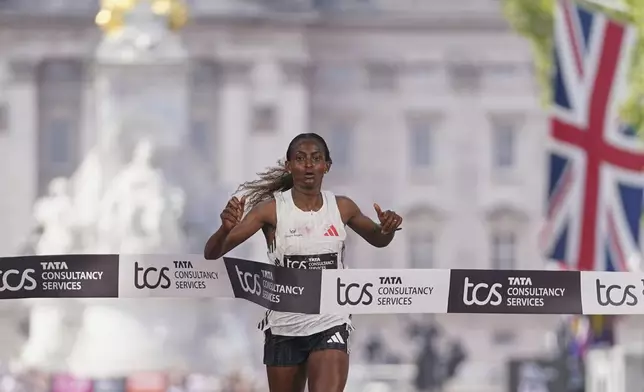 Tigst Assefa crosses the line to win the women's race at the London Marathon, Sunday, April 27, 2025. (AP Photo/Alberto Pezzali)