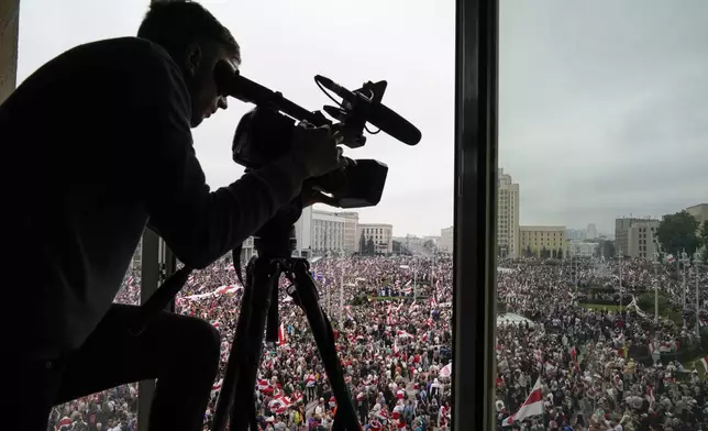 FILE - A cameraman works as Belarusian opposition supporters rally in Independence Square in Minsk, Belarus, on Aug. 23, 2020. (AP Photo/Evgeniy Maloletka, File)