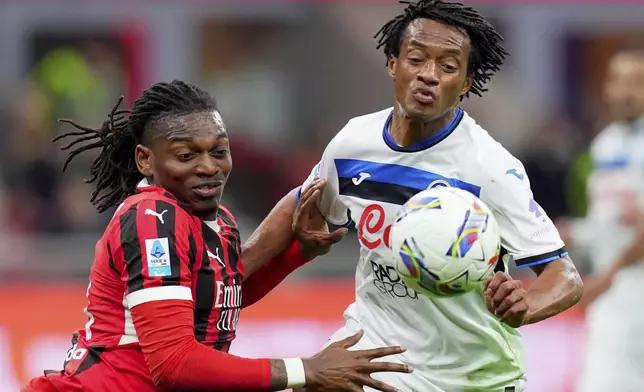 AC Milan's Rafael Leao, left, and Atalanta's Juan Cuadrado in action during the Serie A soccer match between Milan and Atalanta at San Siro Stadium in Milan, Italy, Sunday April 20, 2025. (Spada/LaPresse via AP)