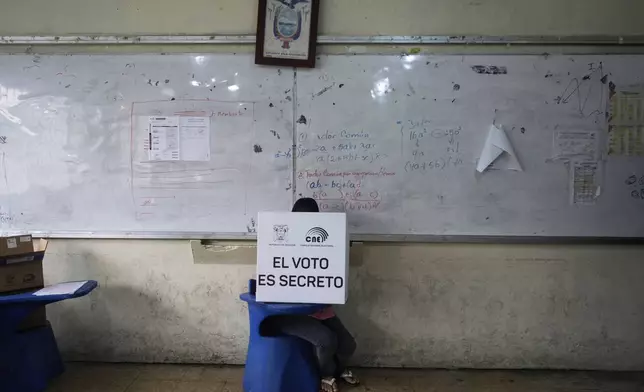 A voter marks the ballot during the presidential election runoff in Olon, Ecuador, Sunday, April 13, 2025. (AP Photo/Fernando Vergara)