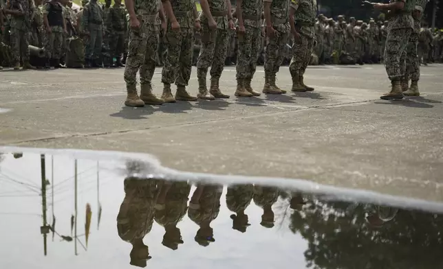 Navy soldiers and reservists stand in formation before heading out to guard polling stations in preparation for Sunday's presidential runoff election, in Guayaquil, Ecuador, Saturday, April 12, 2025. (AP Photo/Fernando Vergara)