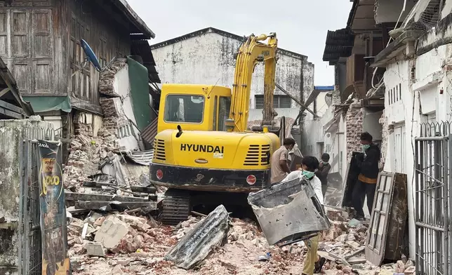 People clean debris from damaged buildings in the aftermath of an earthquake on March 28, in Naypyitaw, Myanmar, Monday, April 7, 2025. (AP Photo)